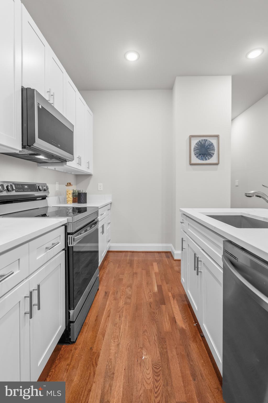 2103 McCulloh Street Baltimore, MD 21217 - Photo 16 of 56 a kitchen with stainless steel appliances granite countertop a sink dishwasher stove and microwave with wooden floor