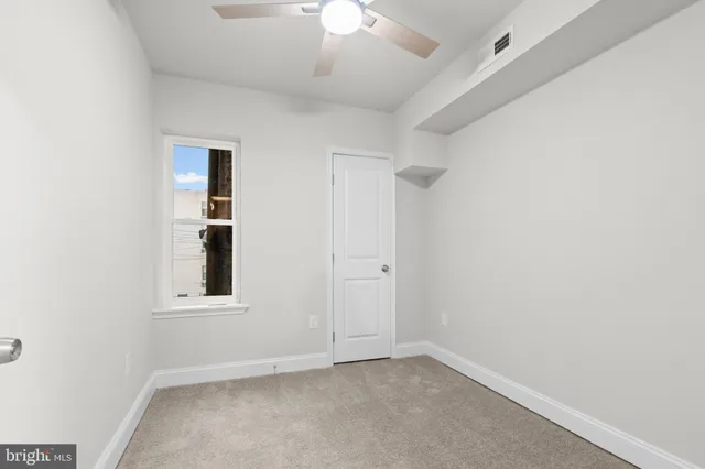 an empty room with a ceiling fan and a window
