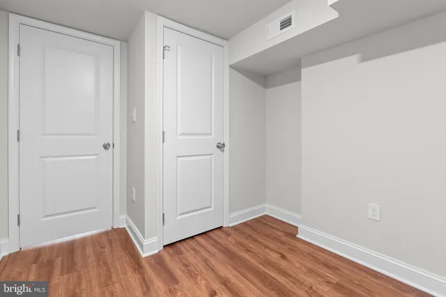 a view of empty room with wooden floor