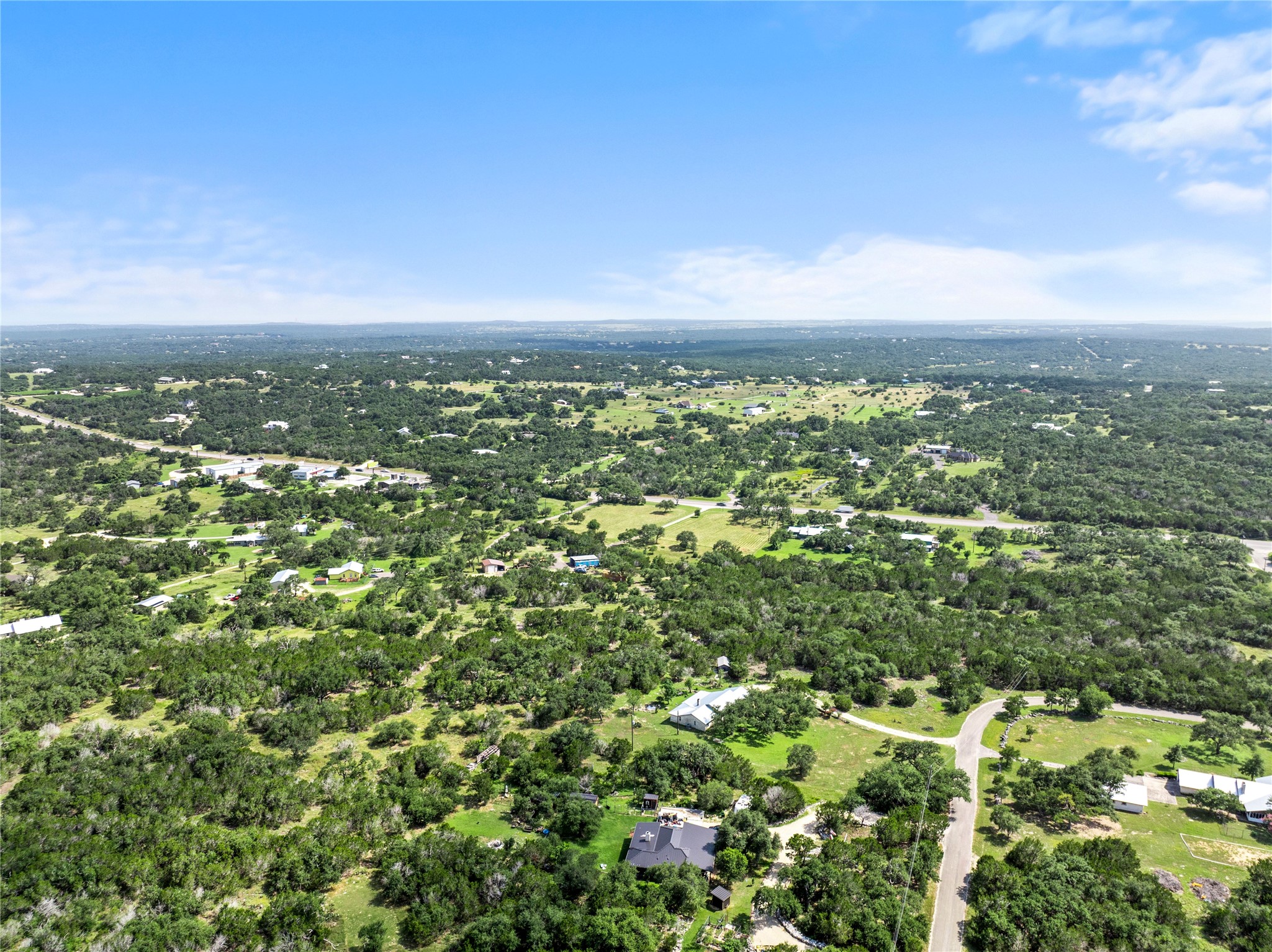 8200 Ranch Road 12 San Marcos, TX 78666 - Photo 36 of 40 An aerial panorama reveals a verdant landscape dotted with homes, offering serene views and natural beauty.