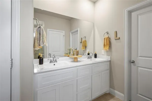 a bathroom with double vanity sink and a mirror