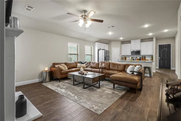 a living room with furniture kitchen view and a chandelier