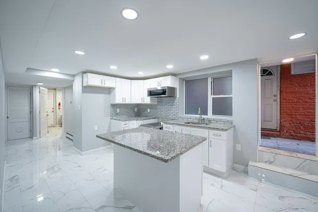a kitchen with stainless steel appliances granite countertop a sink and a refrigerator