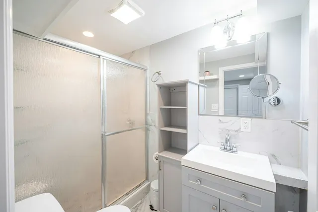 a bathroom with a sink a toilet and shower