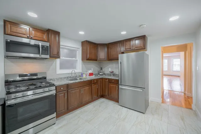 a kitchen with granite countertop a refrigerator stove top oven and sink