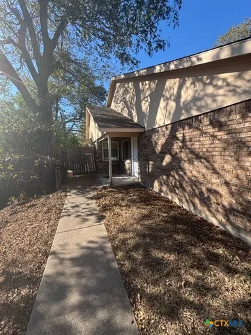 a front view of house with yard and trees around
