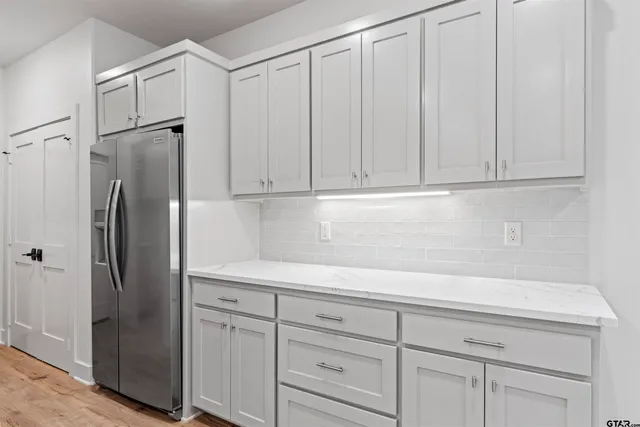 a kitchen with cabinets and a refrigerator