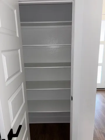 a view of walk in closet with empty racks