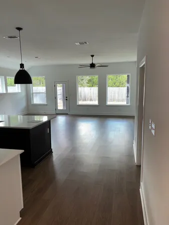 a kitchen with stainless steel appliances granite countertop a stove a sink a window and wooden floor