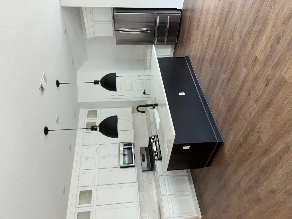 2128 Little Snake Way Georgetown, TX 78633 - Photo 18 of 32 a kitchen with stainless steel appliances a sink a stove and a wooden floor