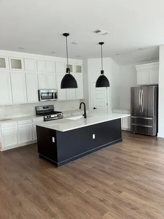 a kitchen with stainless steel appliances a sink a stove a refrigerator and cabinets