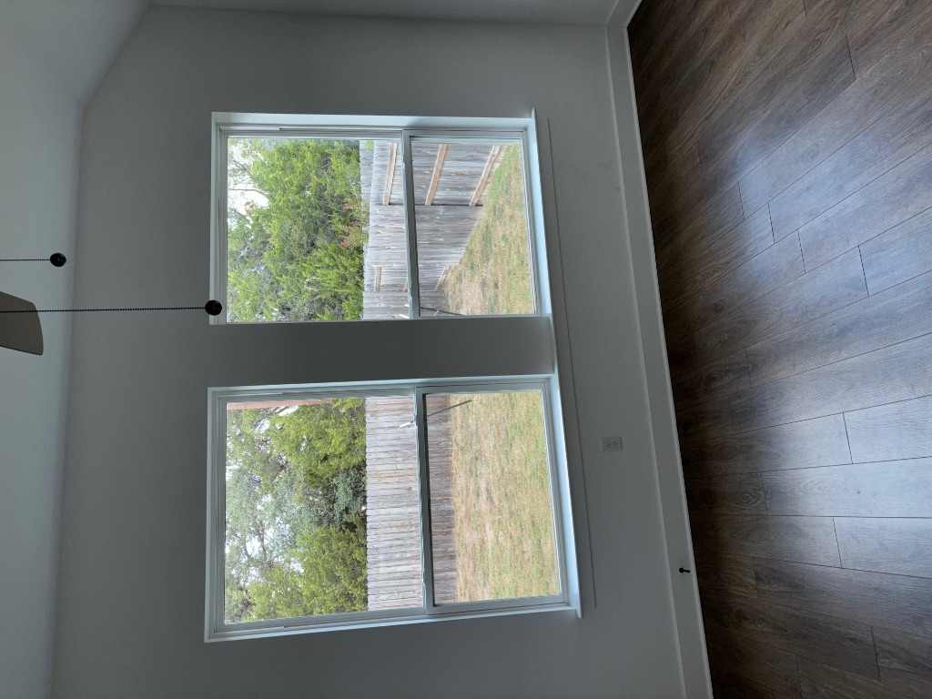 2128 Little Snake Way Georgetown, TX 78633 - Photo 22 of 32 a view of an empty room with wooden floor and a window