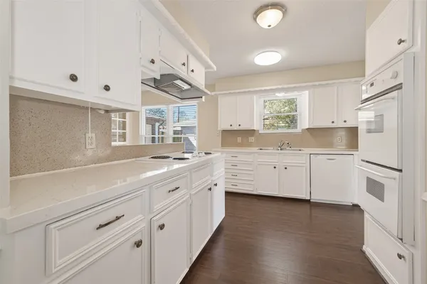 a kitchen with white cabinets and white appliances
