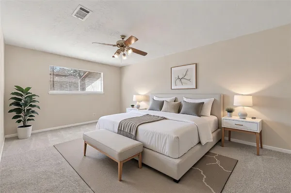 a spacious bedroom with a bed and a potted plant