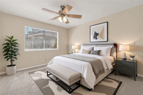 a bedroom with a large bed and a potted plant