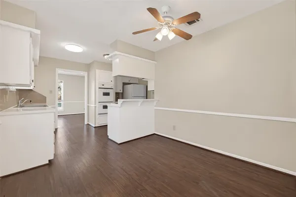 a view of a kitchen with wooden floor and a sink
