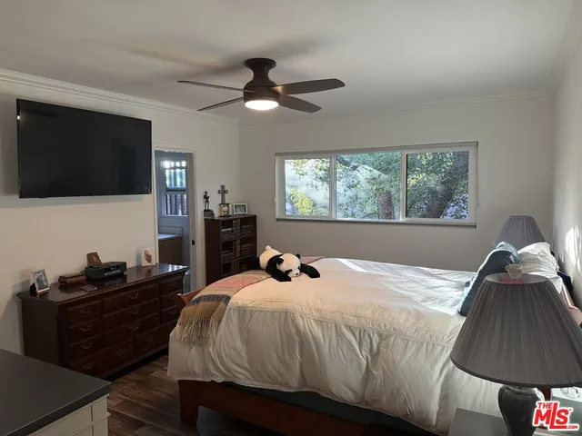 a bedroom with a bed and a flat tv screen on the dresser