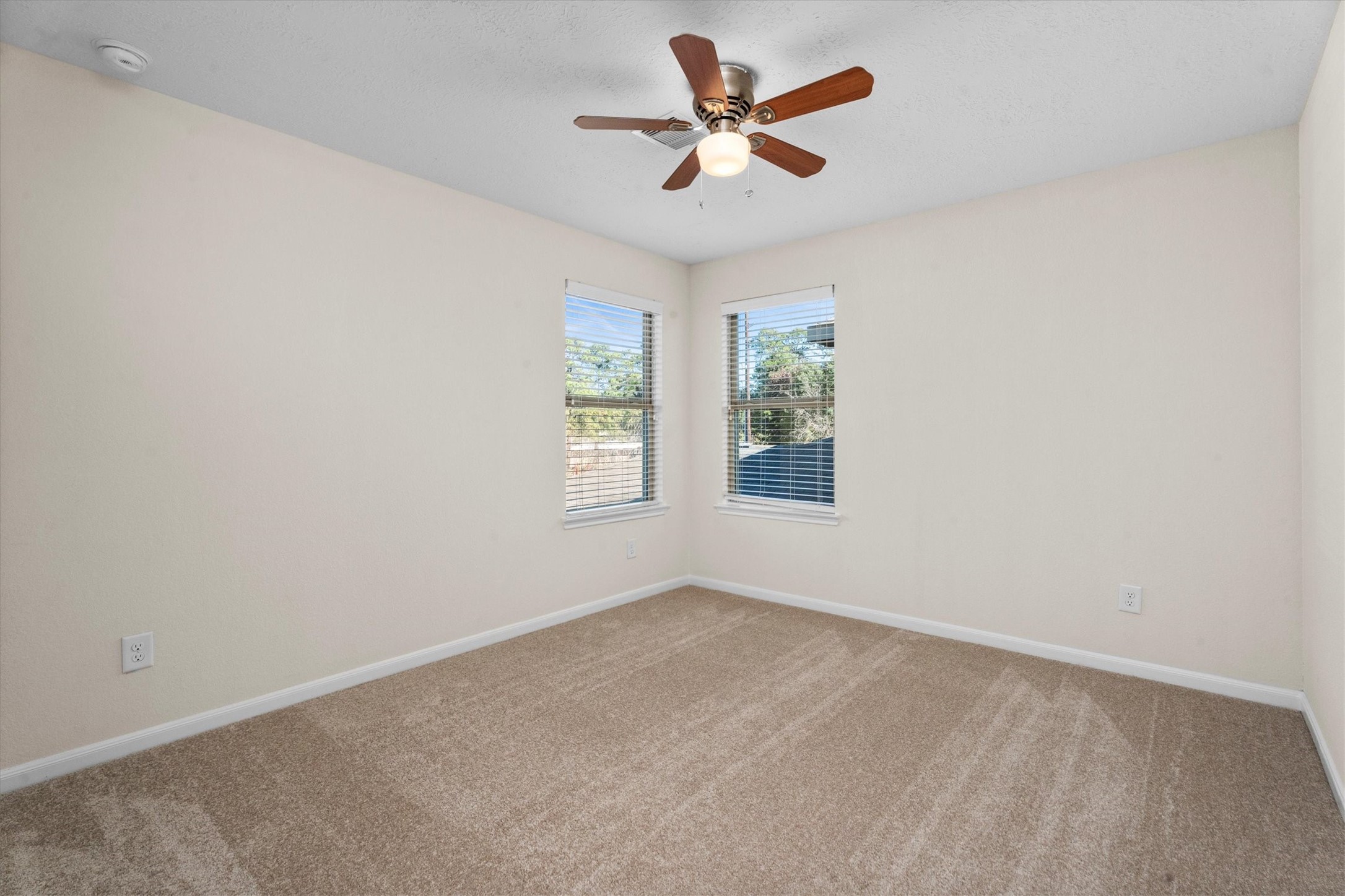 4022 Streambed Trail Houston, TX 77068 - Photo 23 of 32 an empty room with windows and ceiling fan