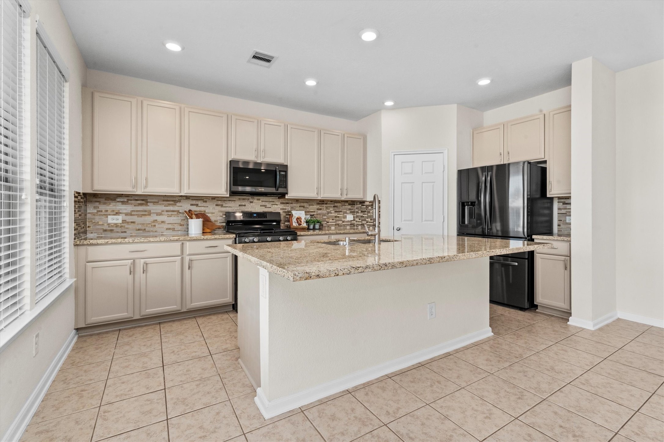 4022 Streambed Trail Houston, TX 77068 - Photo 3 of 32 a kitchen with granite countertop a refrigerator and a stove top oven