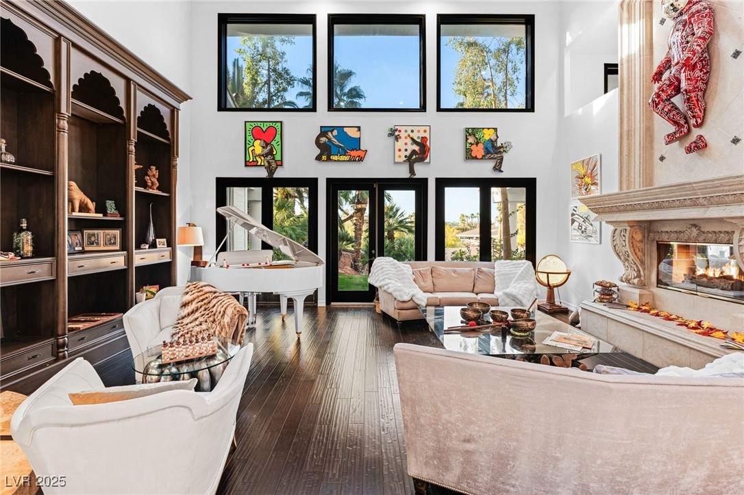 2057 Troon Drive Henderson, NV 89074 - Photo 22 of 41 Living area featuring a towering ceiling, a premium fireplace, and dark wood-style flooring