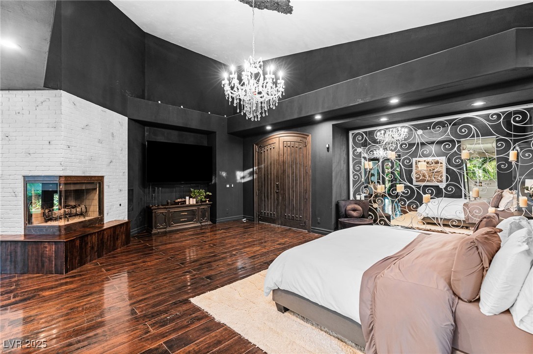2057 Troon Drive Henderson, NV 89074 - Photo 7 of 41 Bedroom featuring hardwood / wood-style floors, a fireplace, and a high ceiling