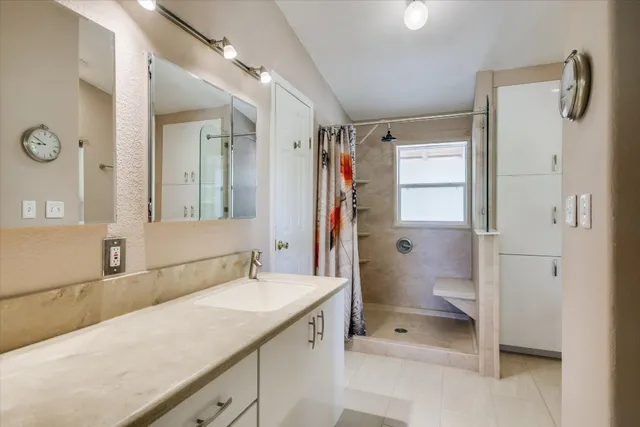 a spacious bathroom with a shower sink and mirror