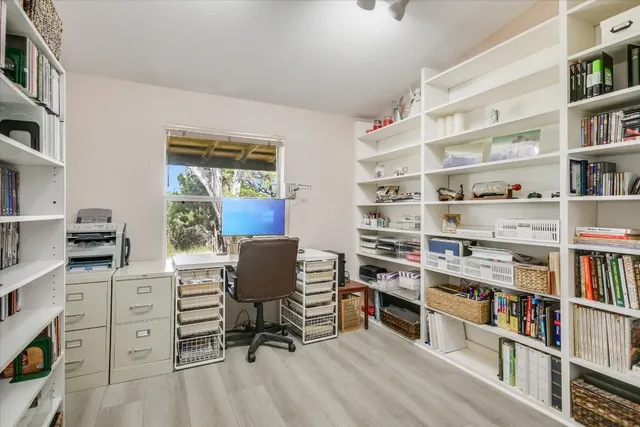 a view of a workspace with furniture and a book shelf