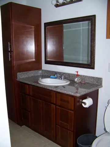 a bathroom with a granite countertop sink and a mirror