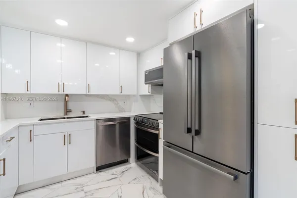 a kitchen with stainless steel appliances granite countertop a refrigerator and a stove
