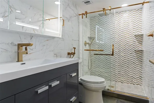 a bathroom with a sink a toilet and shower