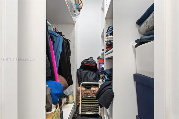 a view of walk in closet with clothes and shoes