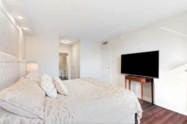 a bedroom with a bed and a flat screen tv