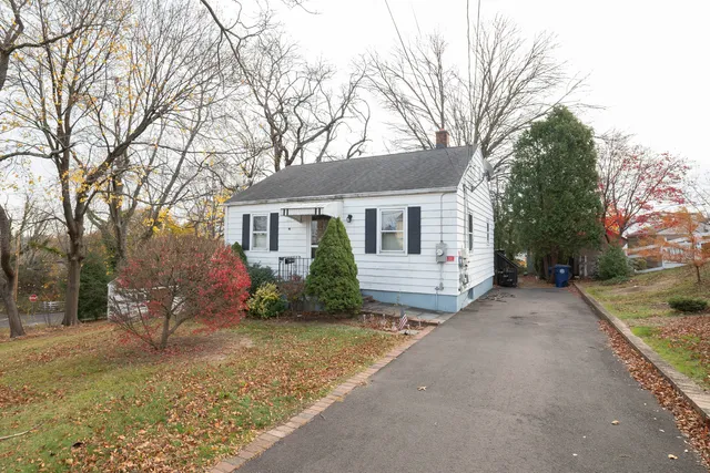 a view of a house with a yard and trees