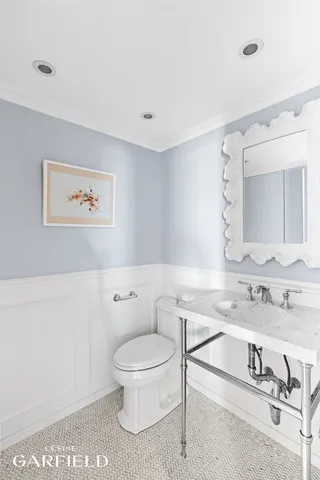 a bathroom with a toilet a sink and mirror