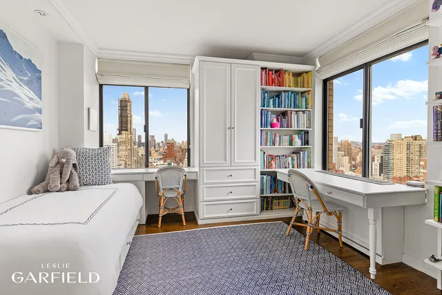 a living room with furniture a bookshelf and a window