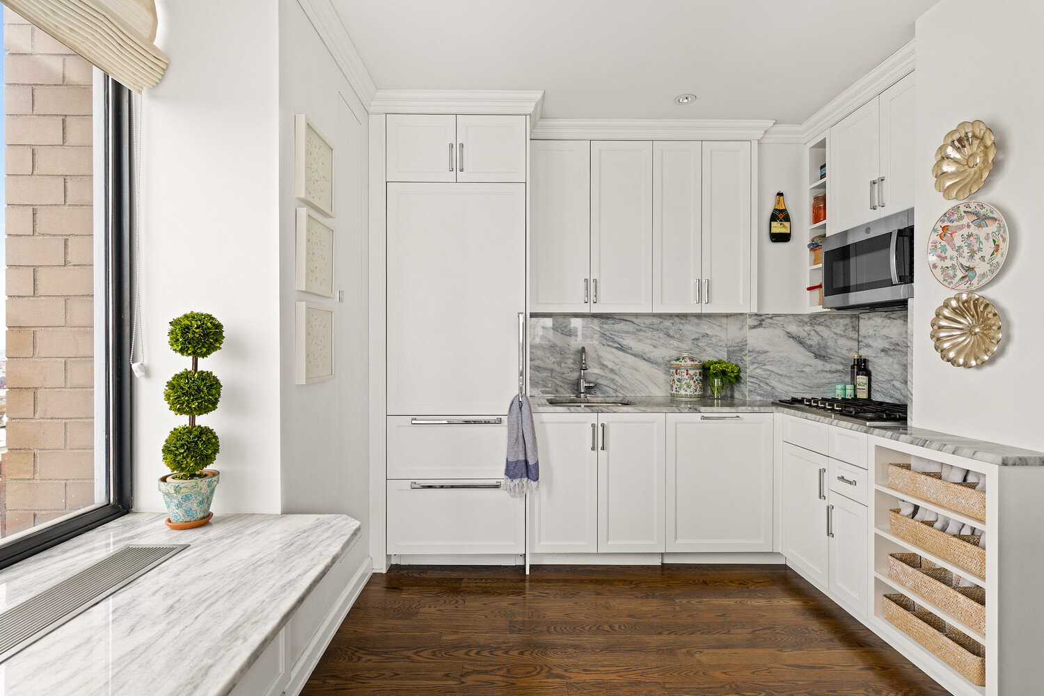 400 East 70th Street, Unit 3602 Manhattan, NY 10021 - Photo 19 of 20 a kitchen with granite countertop a white stove top oven and white cabinets with wooden floor