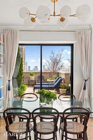a dining room with furniture a rug and a floor to ceiling window