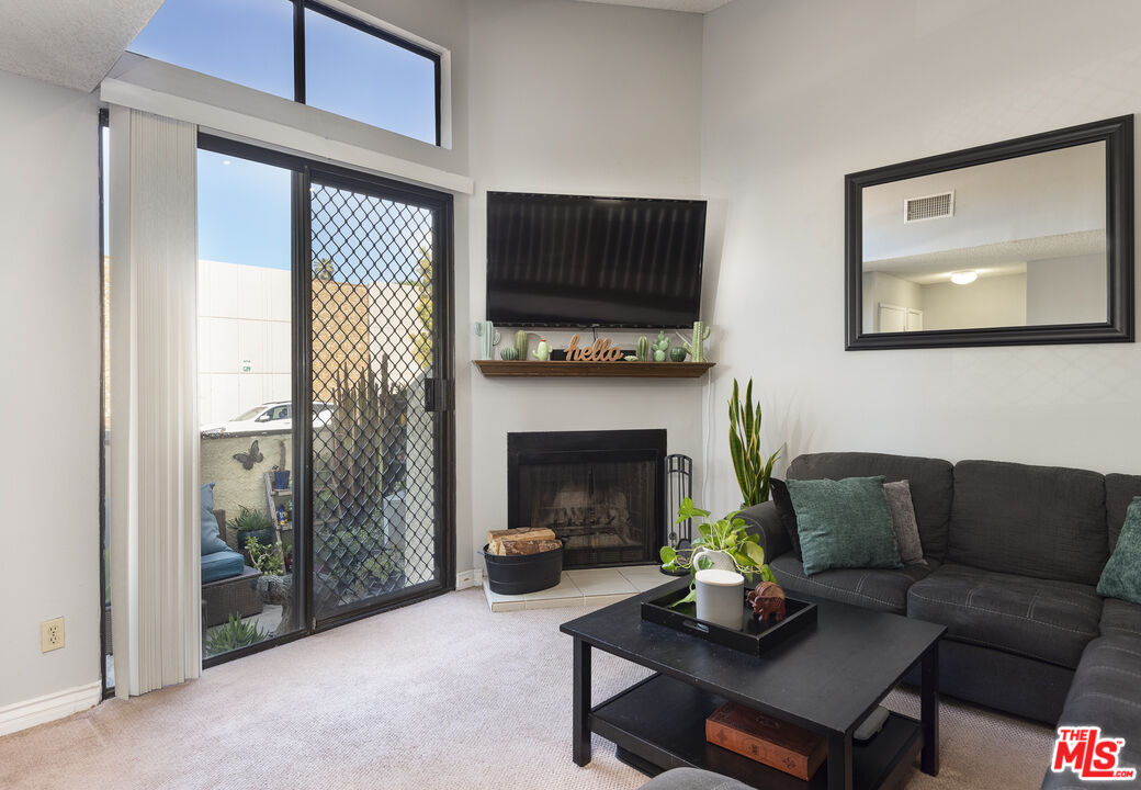 19355 Sherman Way, Unit 37 Reseda, CA 91335 - Photo 4 of 12 a living room with furniture a flat screen tv and a fireplace