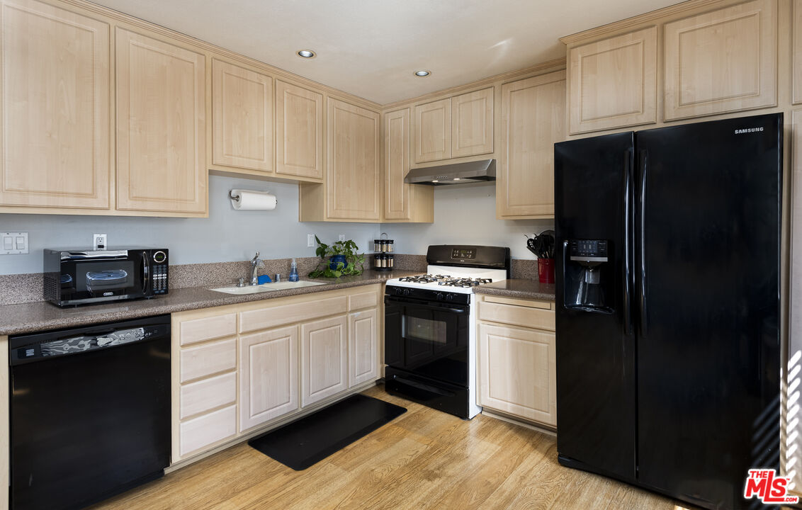 19355 Sherman Way, Unit 37 Reseda, CA 91335 - Photo 5 of 12 a kitchen with a refrigerator stove and white cabinets