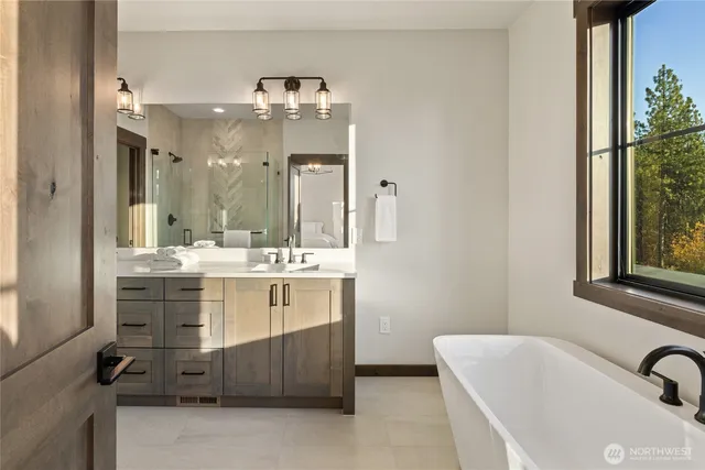 a bathroom with a double vanity sink bathtub and next to a window