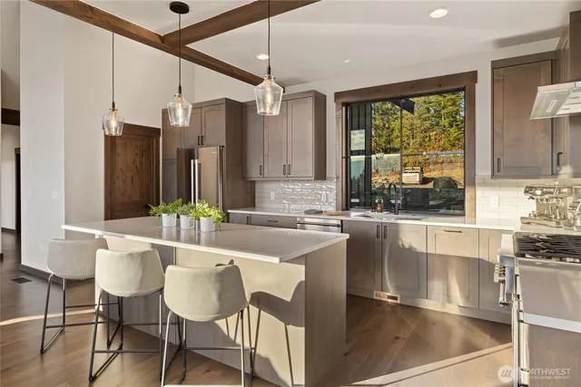 a kitchen with stainless steel appliances a stove a sink cabinets and a refrigerator