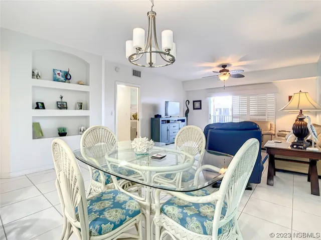 a view of a dining room with furniture a chandelier and wooden floor