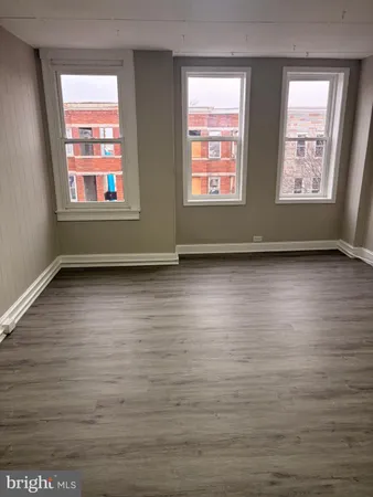 a view of an empty room window and wooden floor