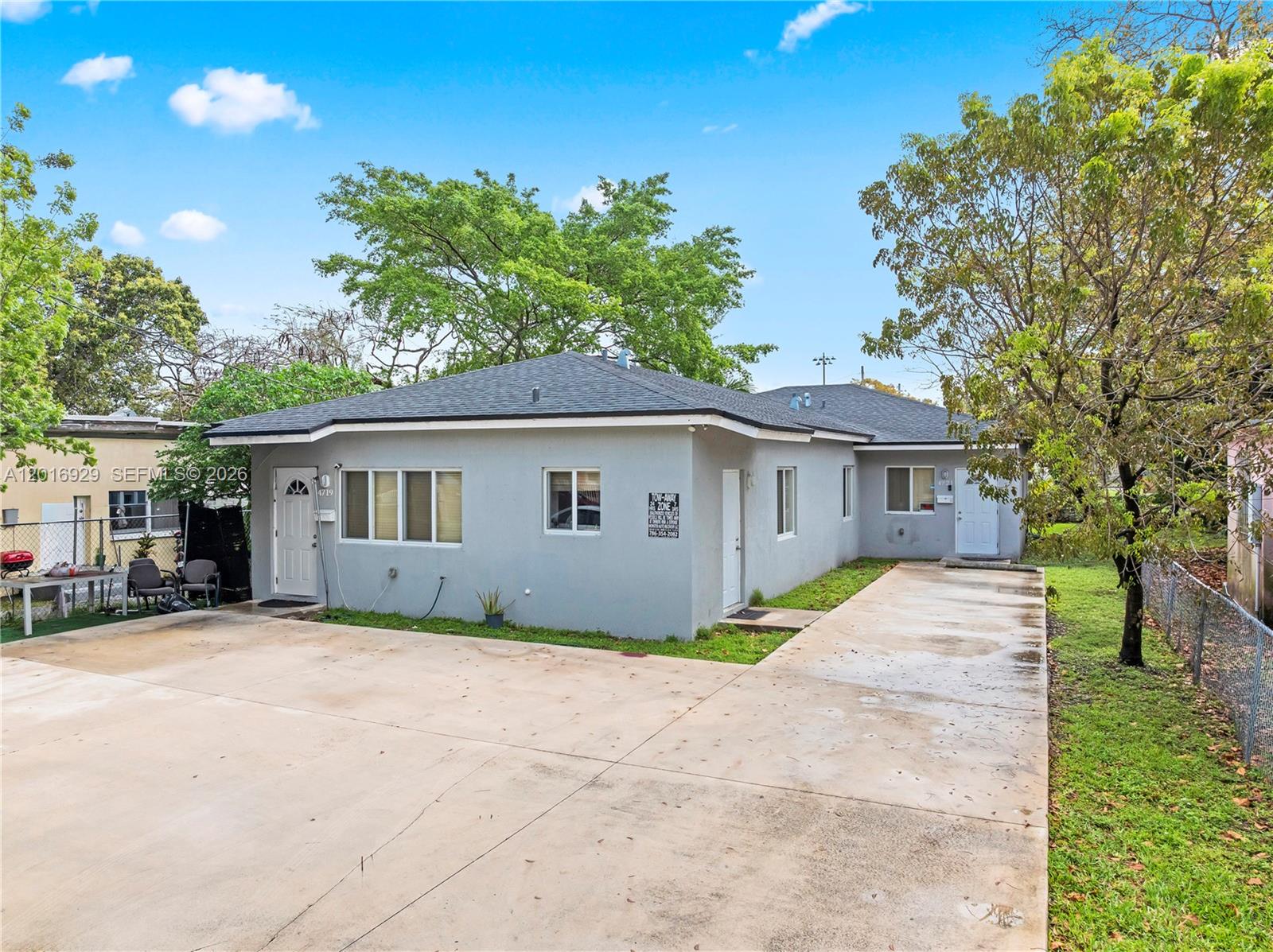 4721 Northwest 15th Court, Unit 1 Miami, FL 33142 - Photo 2 of 11 a front view of house with yard and trees in the background