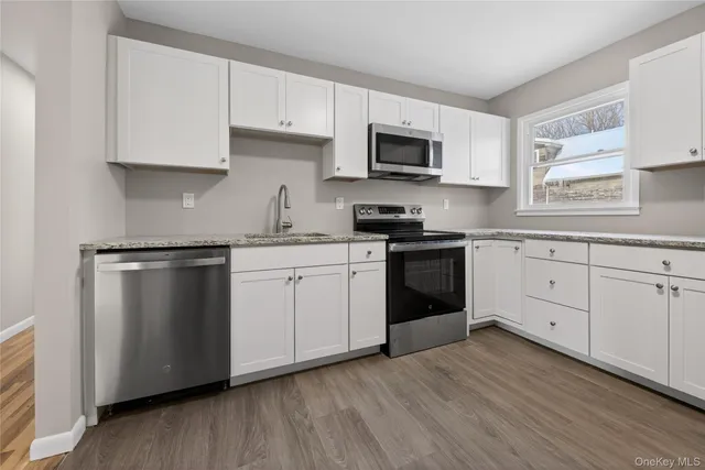 a kitchen with stainless steel appliances a white cabinets and sink