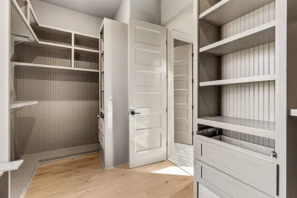 a view of a kitchen with white cabinets and a window