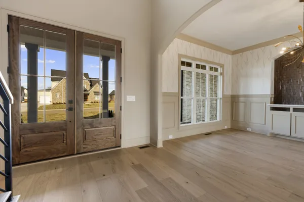 a view interior of a house with wooden floor windows and a chandelier fan