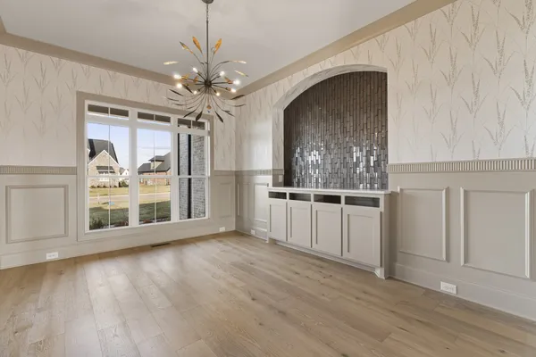 a view of a big room with wooden floor and windows