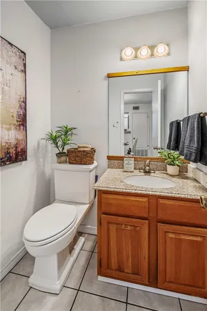 a bathroom with a granite countertop toilet sink and mirror