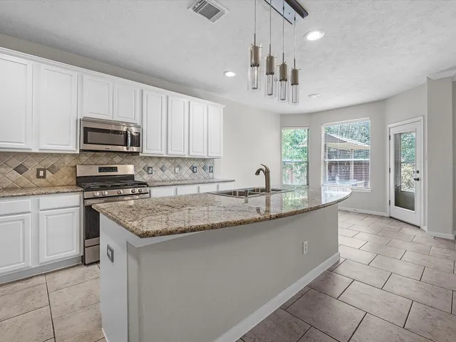 a kitchen with stainless steel appliances granite countertop a sink and a stove